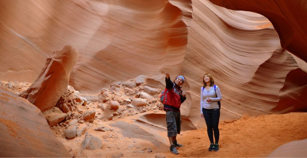 a woman and guide exploring antelope canyon