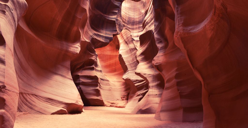view from inside of antelope canyon, layered red rock and the sunrays beaming through