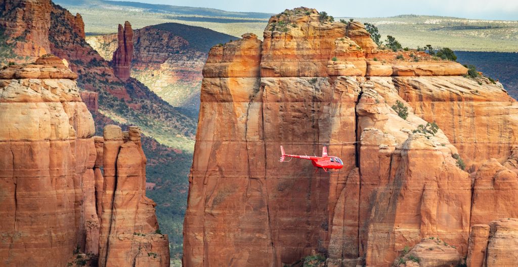 red helicopter flying over sedona