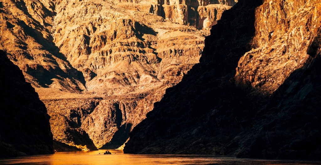 dramatic golden reflection of the grand canyon in the colorado river