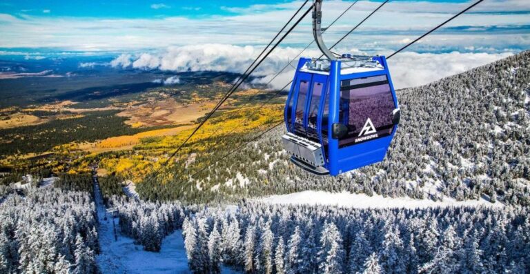 blue gondola at arizona snowbowl with snow up high and fall colors below