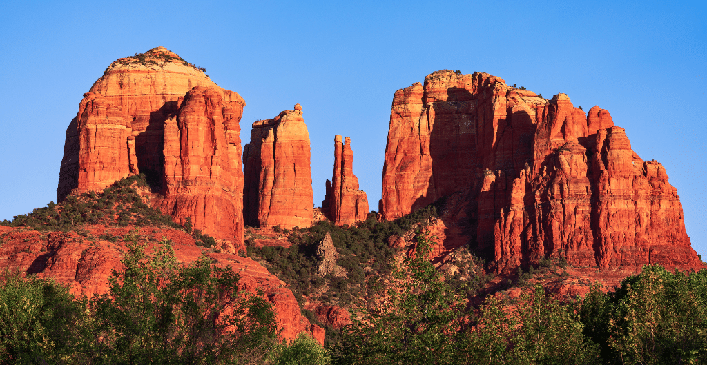 the red rock of cathedral rock lit up by the setting sun while hiking this sedona trail