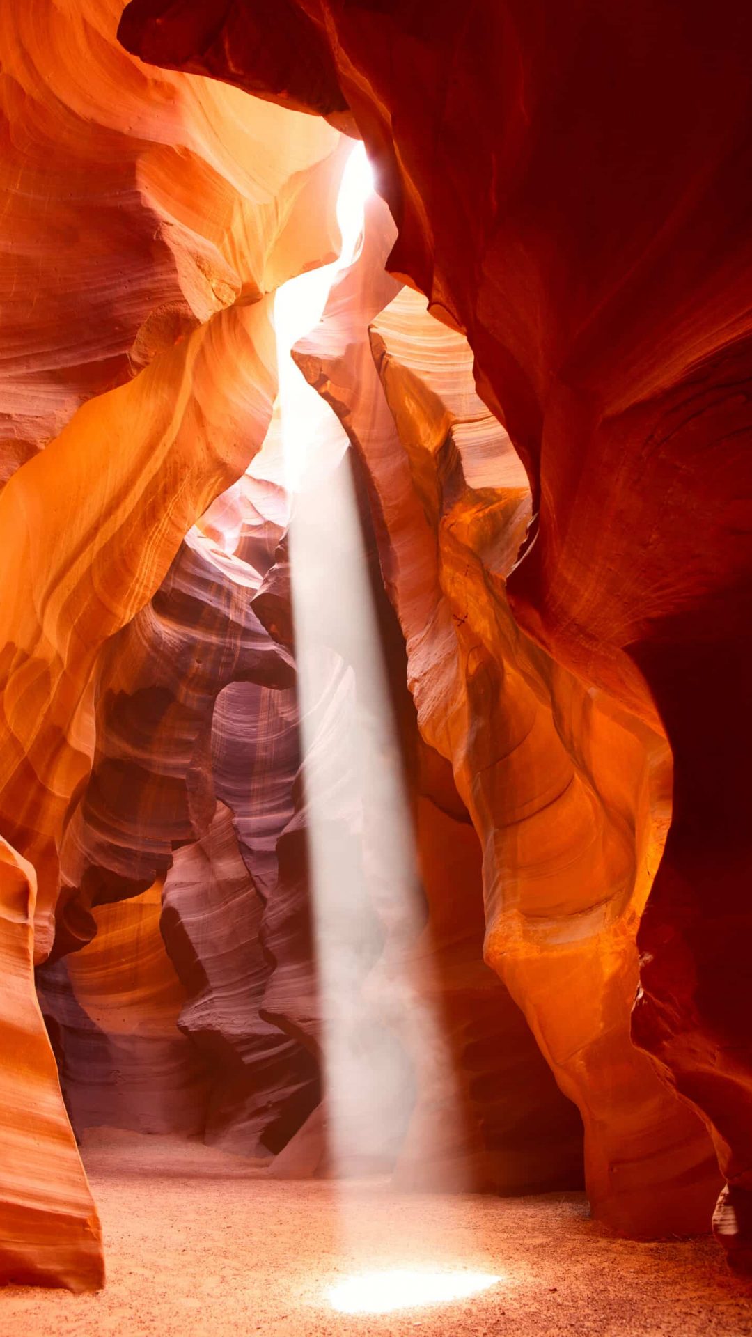 stream of sunlight coming in through the red rocks of antelope canyon